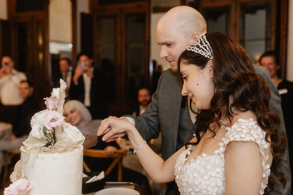 Hochzeitsfotografie Marie Monheim – Das Brautpaar schneidet gemeinsam die Hochzeitstorte in der stilvollen Hochzeitslocation Marienburg Monheim an