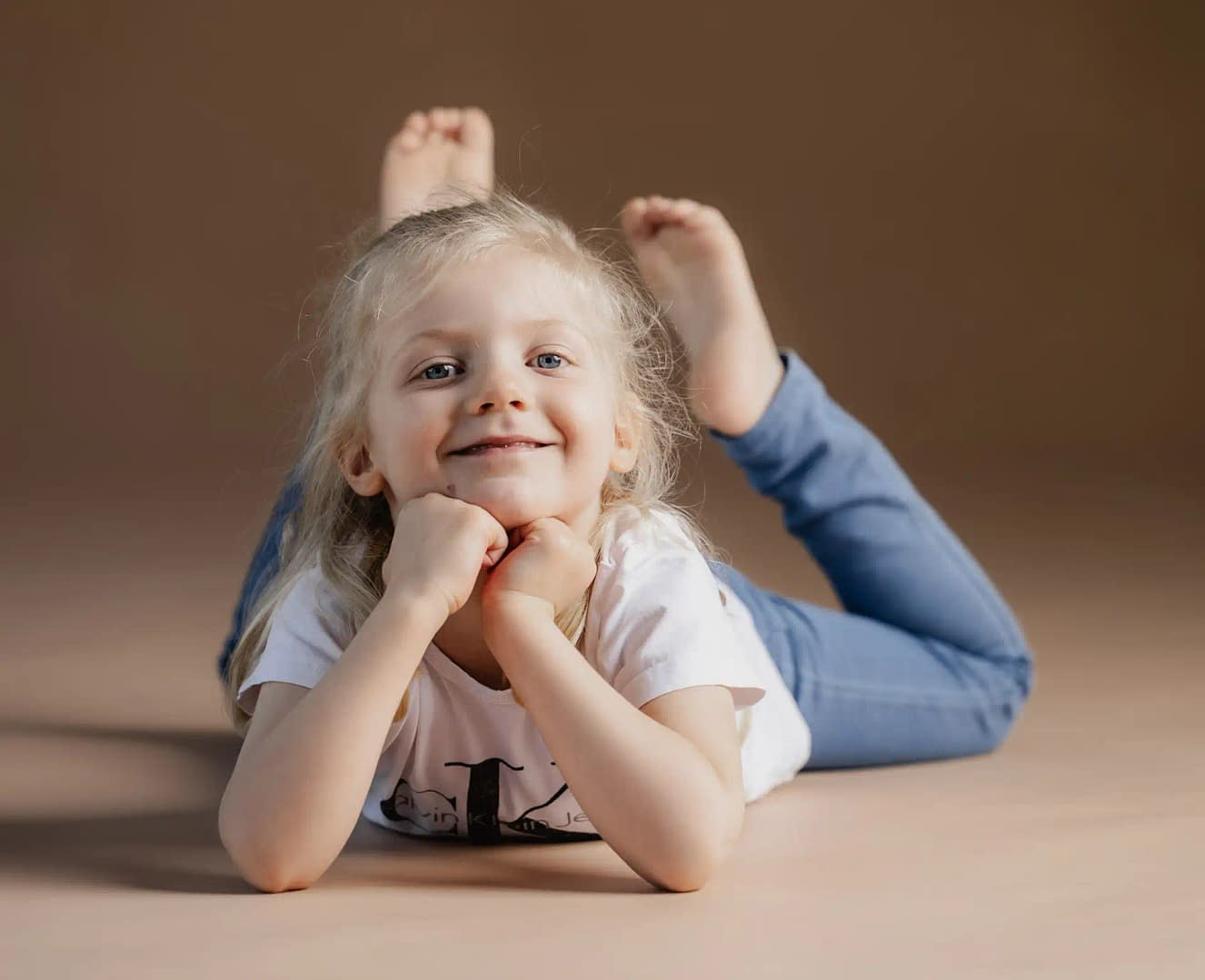Kind liegt auf dem Boden im fotostudio Bielefeld liebevollefotos