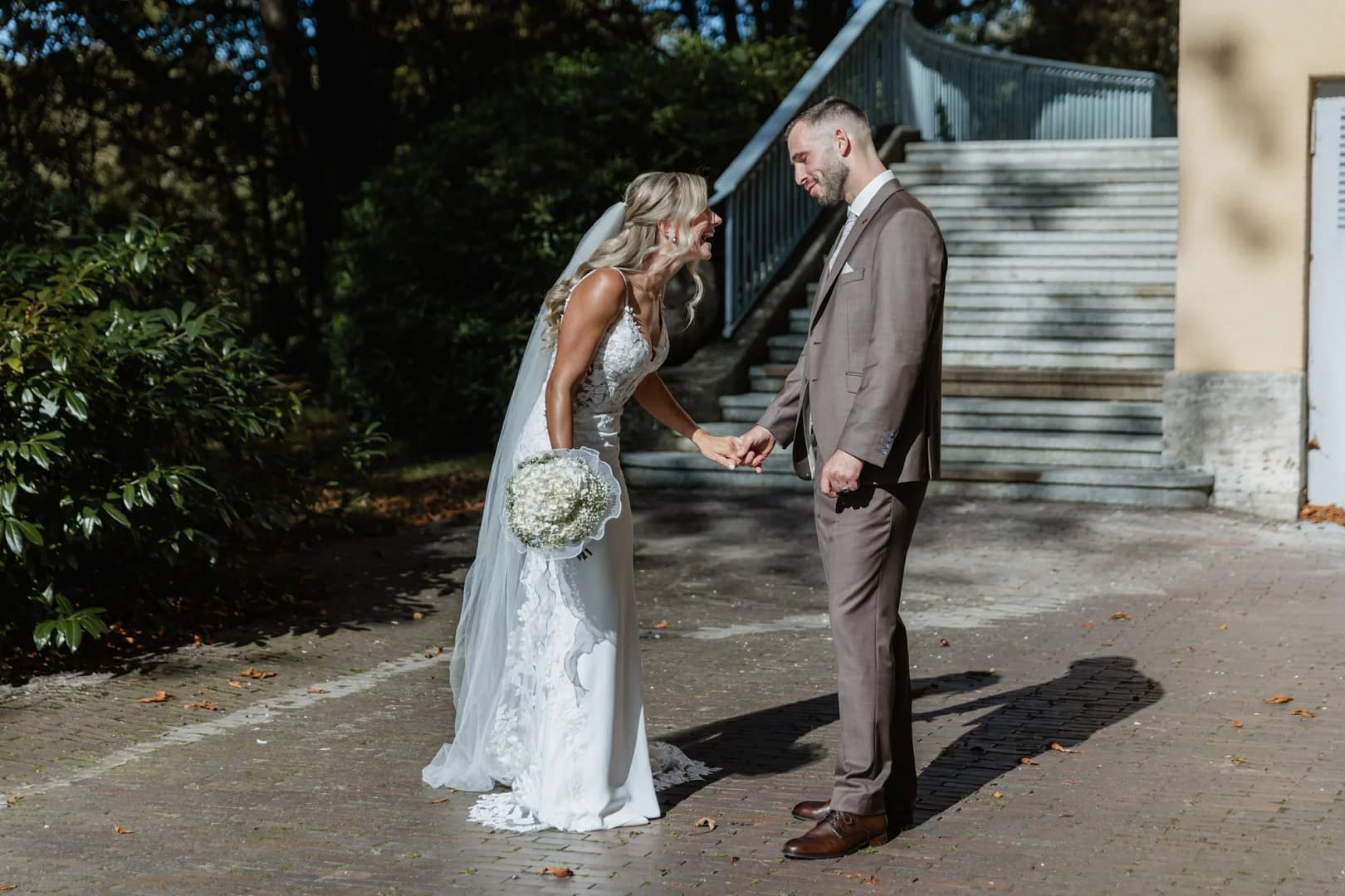 braut lacht hand in hand braeutigam steintreppe
