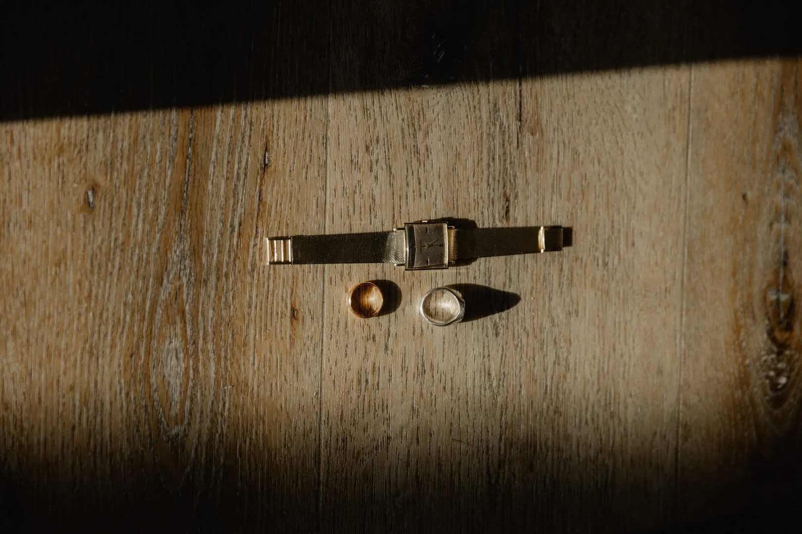 eheringe goldene uhr detail holzboden lichtstreifen