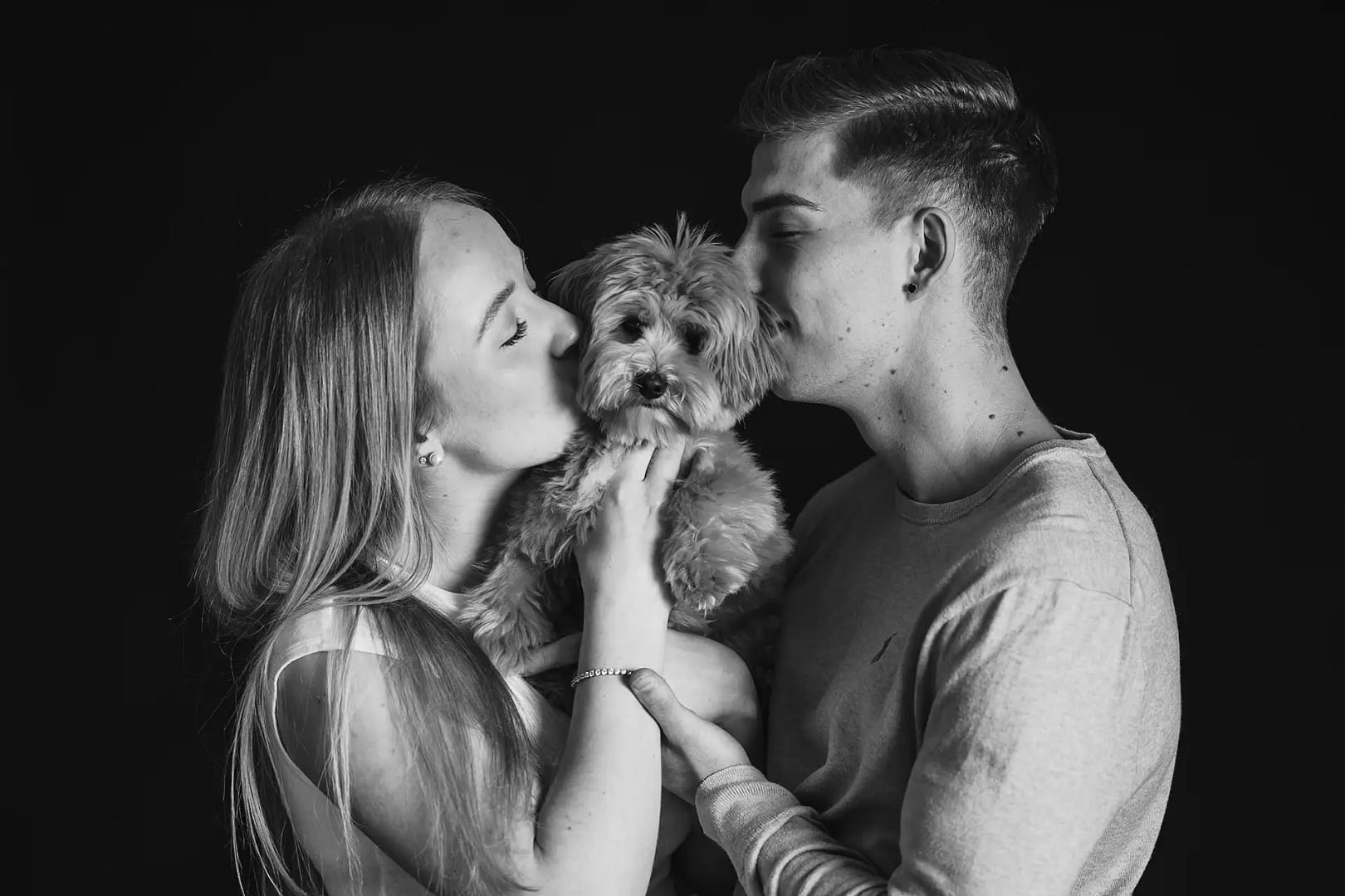 Paarbild mit einem Hund der ein kuss bekommt im Fotostudio Bielefeld liebevollefotos