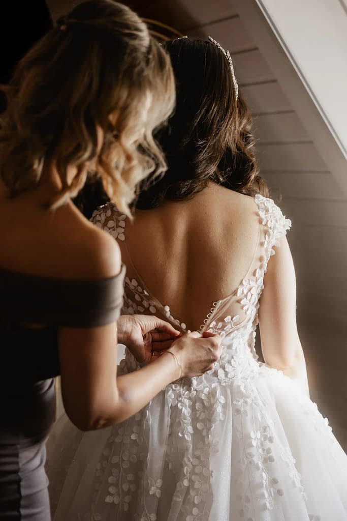 Hochzeitsfotografie Marienburg Monheim Braut zieht das Kleid an