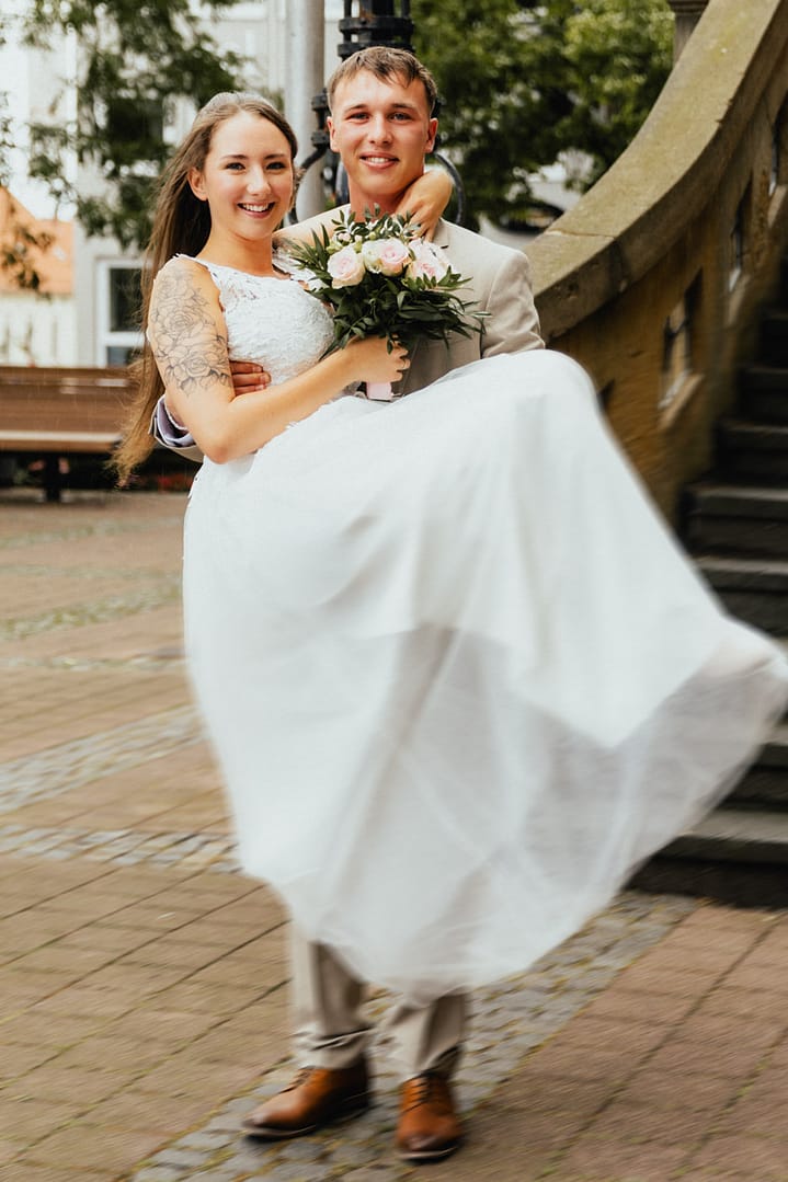 Bräutigam trägt Braut